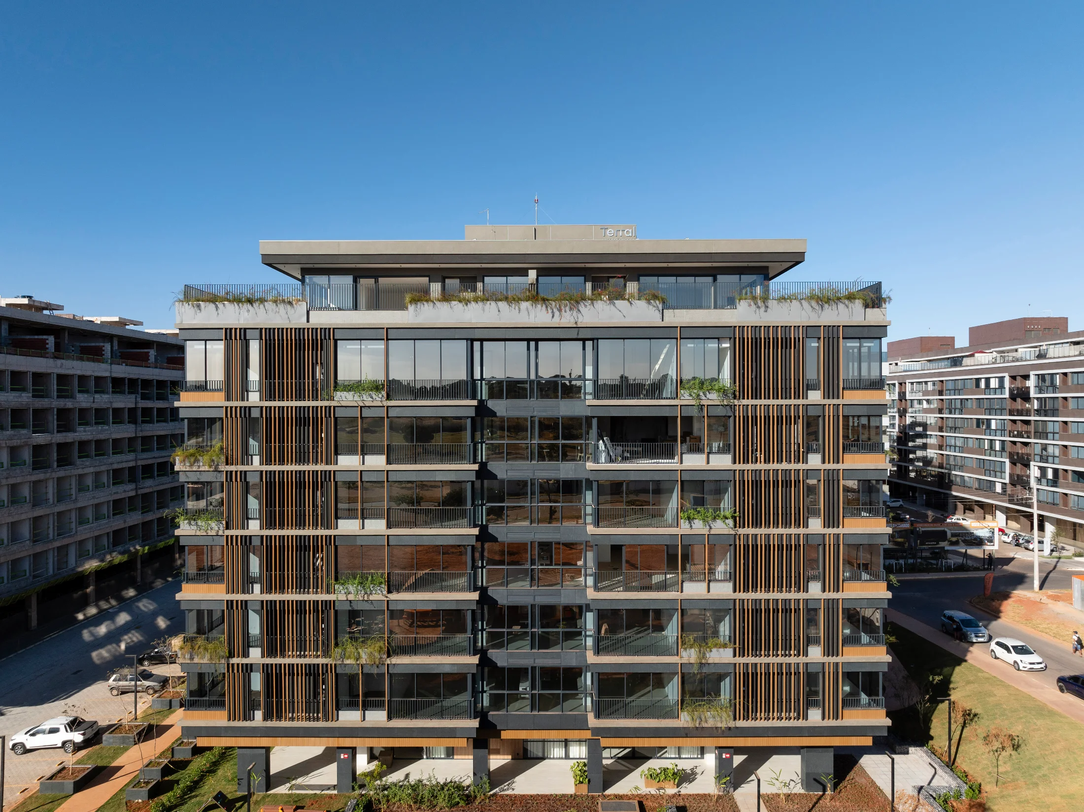Building with a Lesco ecological wood facade, vertical brises and planted balconies.